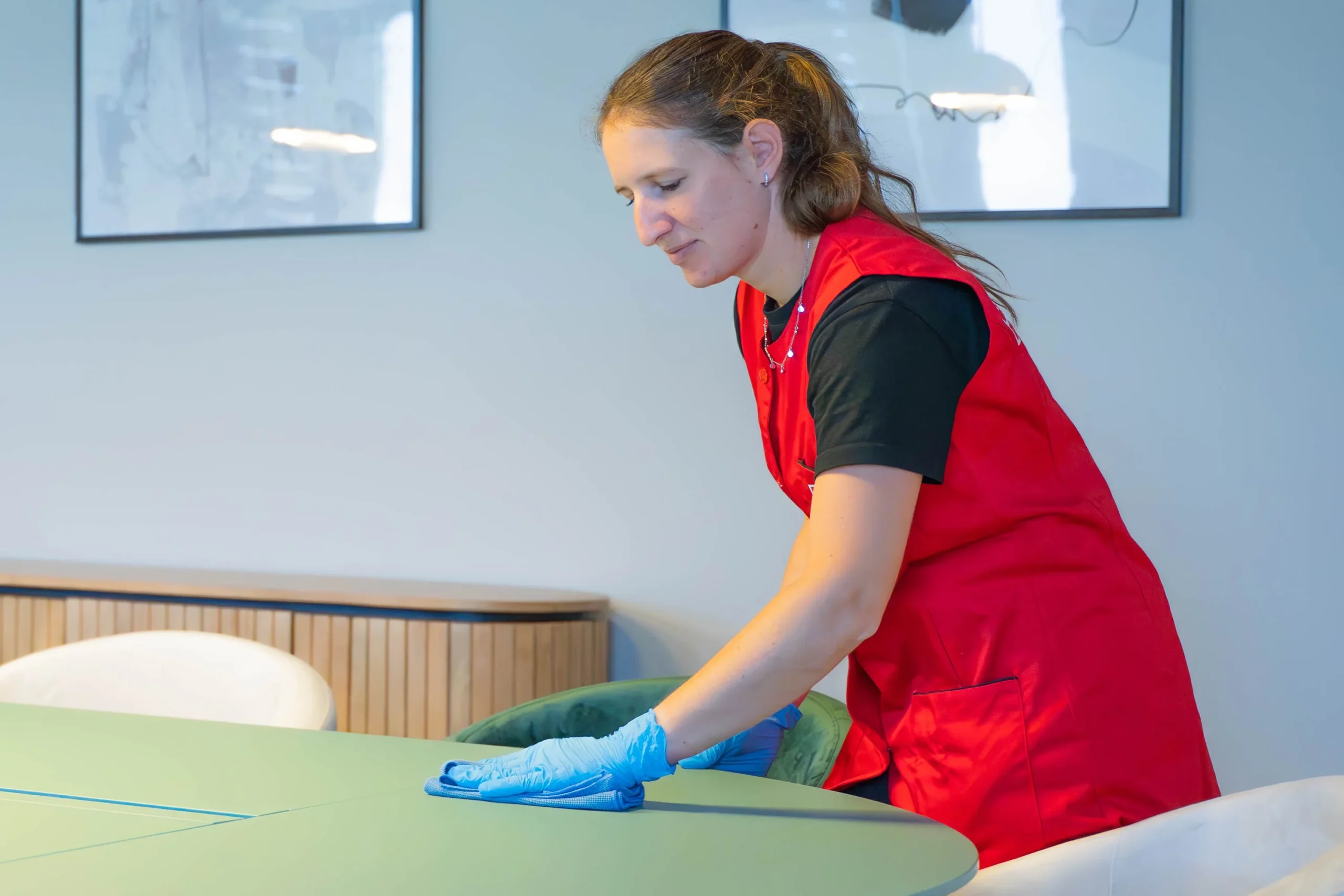 Agent de propreté qui nettoie une salle de réunion dans une entreprise